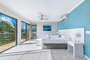 埃尔利海滩Whitsunday Beachfront Apartment on Broadwater的一间卧室设有一张床和一个阳台