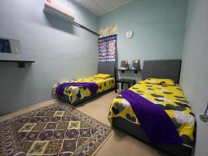 波德申EQ Malay Modest Homestay Port Dickson的一间卧室配有两张床和一张桌子