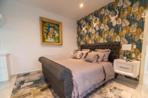 切图马尔Casa Caribe Chetumal的一间卧室配有一张带花卉壁纸的大床