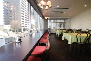 仙台绿线酒店的用餐室配有桌椅和大窗户