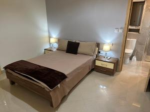 埃尔哥茨拉Ewa Apt - 3-Bedrooms Apt near Sliema - St Julians Seafront的一间卧室配有一张床和两个带灯的床头柜
