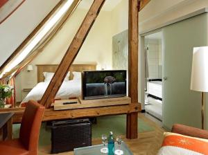 哈姆古特昆普贾斯特隆梅酒店的一间卧室配有一张床和一张桌子上的电视