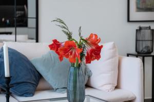 丰沙尔GuestReady - Anakaj House的花瓶里满是红花,坐在桌子上