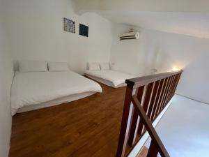 南湾愛玩生活墾丁聚所的小房间设有两张床和楼梯