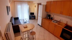 梅塔诺佛希斯Teos的厨房配有沙发、桌子和冰箱。