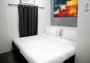 马尼拉mySTAY Hotel BGC South的卧室配有白色的床和黑色窗帘