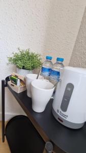 埃普拉特约布里加Barcelona PR Guesthouse的一个带搅拌器、碗和瓶装水的柜台