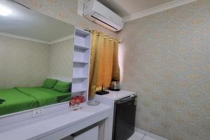 TekoB Nature Aeropolis Inn的小房间,在柜台上摆放着绿色的床