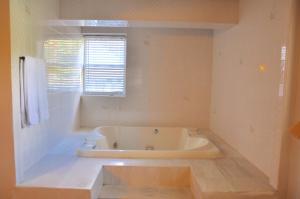 菲什基尔乡村汽车旅馆的带窗户的浴室内的白色浴缸