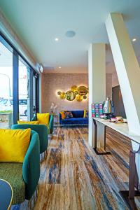 下哈特The Sebel Wellington Lower Hutt的客厅设有黄色和蓝色的家具,铺有木地板。