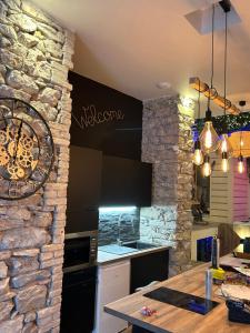 格勒诺布尔Grenoble LA SUITE 2 spa jaccuzzi et sauna privatif的厨房设有石墙和桌子