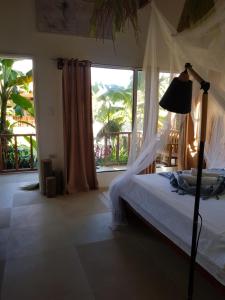 卢纳将军城Tropical Bungalows-Siargao的一间卧室设有一张床和一个大窗户