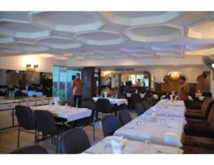 那格浦尔Hotel Sukhakarta, Nagpur的一间设有白色桌椅的用餐室
