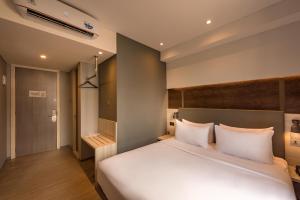 雅加达Stanley Wahid Hasyim Jakarta的卧室配有带白色枕头的大床