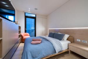 悉尼Paragon的一间卧室配有一张带蓝色毯子的床