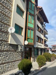 班斯科Apartment in Bansko, very close to the Gondola的一座石头外墙建筑,上面有标志