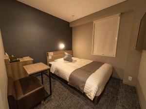 仙台Super Hotel Premier Sendai Kokubuncho Tennenonsen的一间小卧室,配有床和窗户
