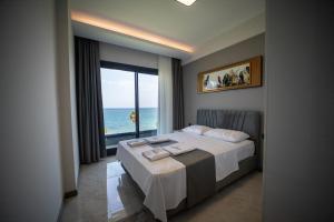 古泽尔坎里Artan Suites Tatil Evleri的一间卧室设有一张床,享有海景