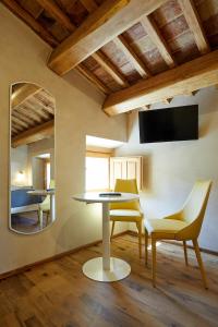 马西尼亚诺Agriturismo Montecolombo by Il Ritorno的一间带桌椅和镜子的用餐室