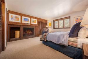 提顿村Bray House - Ski-in Ski-out family home的一间卧室设有一张大床和一个壁炉