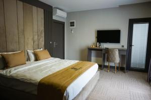伊斯坦布尔Aram Otel Business & Luxury的酒店客房设有一张大床和一张书桌。