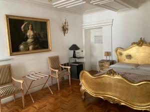 罗马D.R.罗马西班牙豪华套房 的一间卧室配有一张床、一幅画和椅子