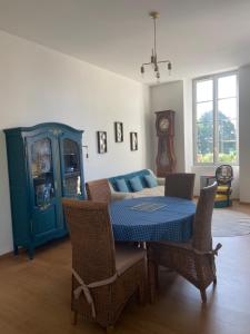 多勒Chez Faustin et Félicie Appartement 2 chambres Place Grevy的一间配备有蓝色桌子和椅子的用餐室