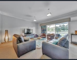 穆尔瓦拉Golf Views Apartment的客厅配有两张沙发和一台电视