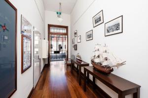 弗里曼特Fremantle Harbourside Luxury Apartments的一间房间,有两张桌子,墙上有一艘模型船