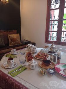 塞拉Riad Dar Badiaa的盘子,杯子,盘子的桌子