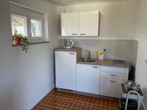 普莱曼图拉Apartment Tulip的厨房配有白色橱柜和水槽