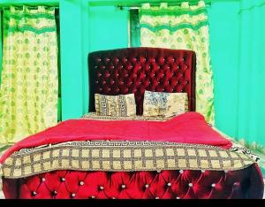 NarulKashmir premium hotel的一张带红色被子和枕头的床