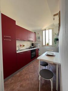 皮佐Pizzo Central House的厨房配有红色橱柜和桌椅