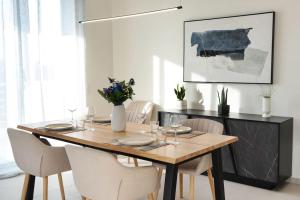 干尼亚Lamzi's Residence的一间带木桌和白色椅子的用餐室