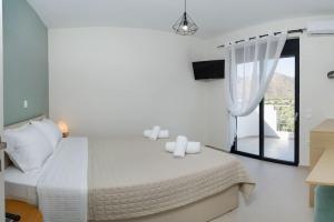 干尼亚Lamzi's Residence的白色的卧室设有床和窗户