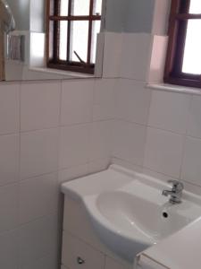 格拉斯科普Westlodge at Graskop B&B的白色的浴室设有水槽和镜子
