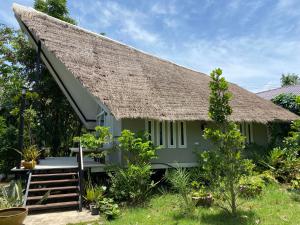 拉差汶里Royal mountain view Ratchaburi的绿色小屋,设有茅草屋顶