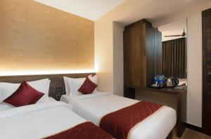 钦奈SUPREME STAY的酒店客房设有两张床和橱柜。