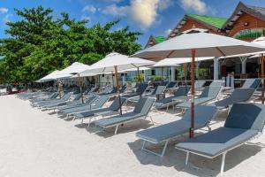 曾蒙海滩湾海滩度假酒店的海滩上的一排椅子和遮阳伞
