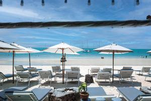 曾蒙海滩湾海滩度假酒店的海滩上设有椅子和遮阳伞,还有大海