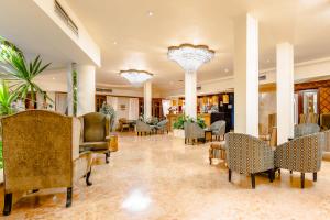 赫尔格达The Grand Hotel, Hurghada的大堂设有桌椅和吊灯。