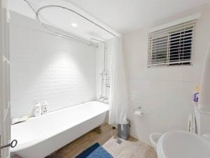 悉尼Pyrnmont Terrace & Townhouse的白色的浴室设有浴缸和卫生间。