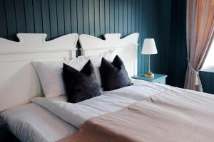 瓦尔河谷Sylte Hotell, Valldal的一张带两个黑色枕头的白色床