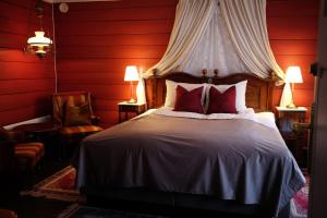 瓦尔河谷Sylte Hotell, Valldal的一间卧室设有一张带红色墙壁的大床