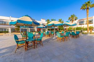 赫尔格达The Grand Hotel, Hurghada的一组桌椅和遮阳伞