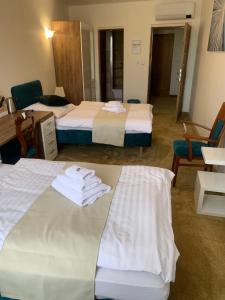 特伦钦Penzión Deloris的两张位于酒店客房的床,配有毛巾