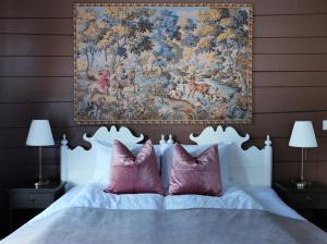 瓦尔河谷Sylte Hotell, Valldal的挂在床上的挂着粉红色枕头的挂毯