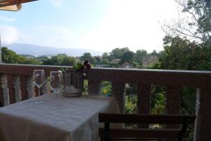 尼格兰Swimming pool, beach and garden in Nigran的阳台上的桌子上放着两杯和一桶水