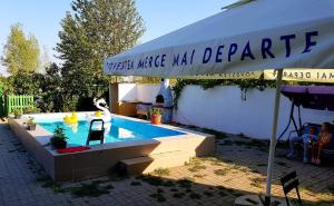 维纳斯Vila Orizont的一个带遮阳伞的庭院内的游泳池