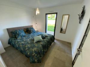 孔卡尔诺2 Maisons de vacances Sittelles Lodge的一间卧室配有一张带蓝色床单和镜子的床